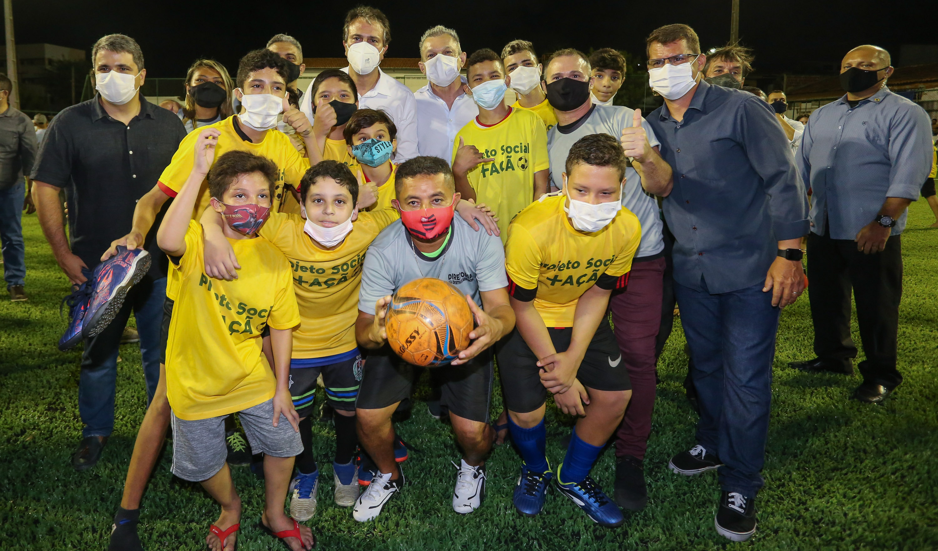 sarto e camilo posam para a foto ao lado de meninos do projeto areninhas